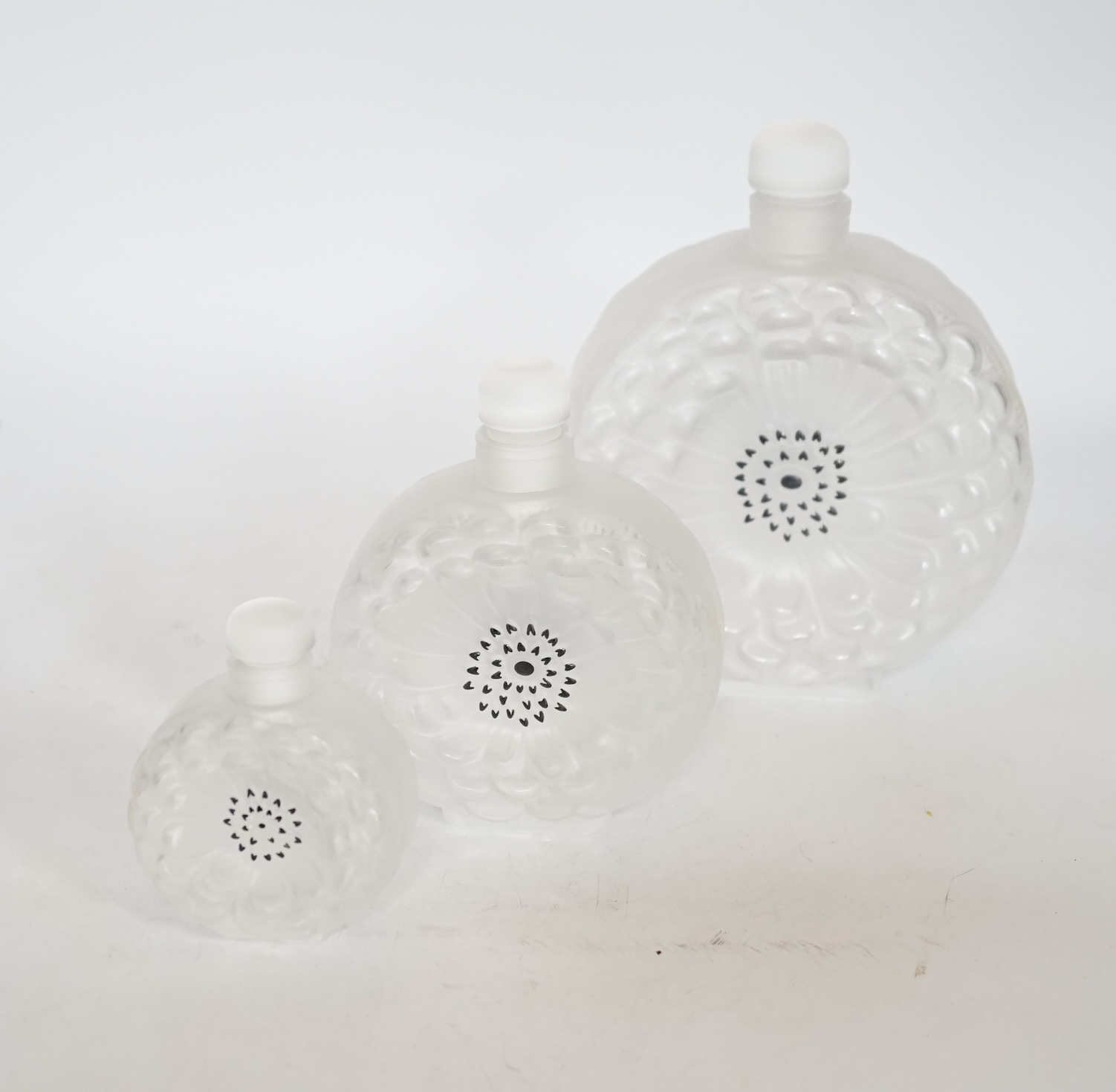 Three graduated Lalique Dahlia pattern glass scent bottles and stoppers, signed to the bases, largest 18cm high